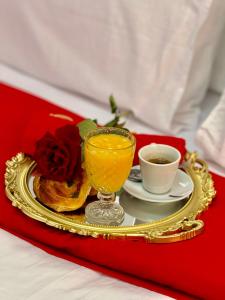 a tray with a glass of orange juice and a cup of coffee at The Hotel Syracuse in Casablanca