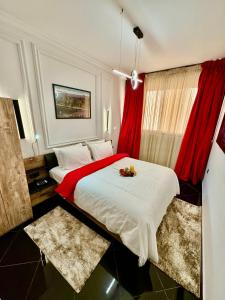 a bedroom with a large bed with red curtains at The Hotel Syracuse in Casablanca