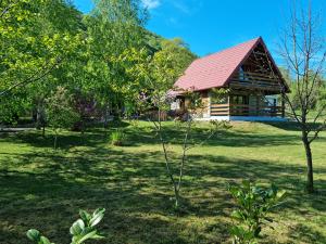 een huis in het midden van een tuin met bomen bij Green Garden Lohovo in Bihać