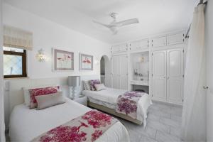 a white bedroom with two beds and a refrigerator at Luxury Villa, Very Close to Beach + Restaurants, WI FI, Heatable Pool. in Sesmarias +16 photos