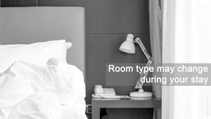 una camera con letto e lampada e tavolo con telefono di Grand Hotel Playa a Lignano Sabbiadoro
