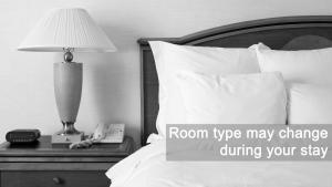 een kamer met een bed met een lamp en een telefoon bij Grand Hotel Playa in Lignano Sabbiadoro