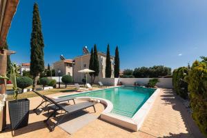 a swimming pool in a yard with a villa at Lagonisi Luxury Escape in Lagonissi