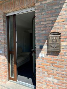 un mur en briques avec une porte et une boîte aux lettres dans l'établissement Peonia and Mughetto apartments in the Langhe, à Albaretto Della Torre 