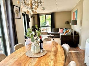 Ewijk的住宿－6p Boshuis 'De Groene Specht' met hottub，客厅配有带一瓶葡萄酒的桌子