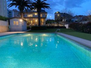 a large swimming pool in front of a house at Chalet con Piscina Privada in Santander