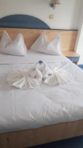 two swans are sitting on a white bed at BRIZA Boutique Hotel Mamaia in Mamaia
