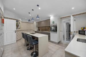 a kitchen with a counter and some chairs in it at Luxury Villa, Very Close to Beach + Restaurants, WI FI, Heatable Pool. in Sesmarias