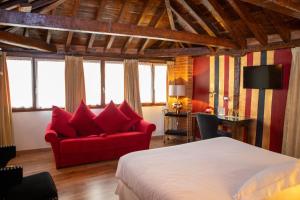 una camera da letto con un letto e un divano rosso di Hotel Boutique Posada Castañeda a Granada