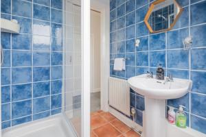 bagno con piastrelle blu, lavandino e vasca di Modern Stylish Cambridge Pad (Free Parking) a Histon