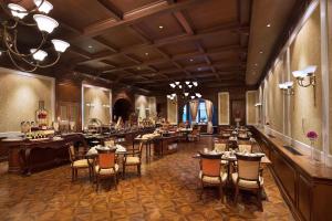 Welcomhotel by ITC Hotels, The Savoy, Mussoorie في موسوري: مطعم بطاولات وكراسي في غرفة كبيرة