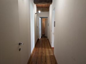 um corredor vazio com paredes brancas e pisos de madeira em Dimora Storica Casa Vanni em Villadossola