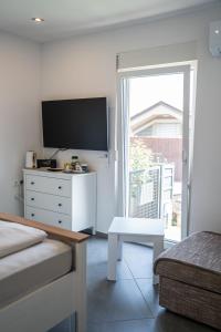 a living room with a tv and a white dresser at Perfect stay in Šentilj