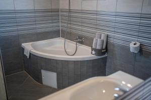 a bathroom with a bath tub and a sink at Perfect stay in Šentilj
