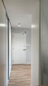 - un couloir avec une porte blanche et du parquet dans l'établissement Spacieux Appartement Familial *10mn saint Charles*, à Marseille