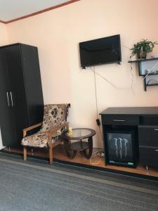 uma sala de estar com uma televisão, uma cadeira e uma mesa em Guest House in Drachino em Svalyava