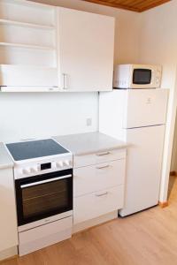 Il comprend une cuisine blanche équipée d'une cuisinière et d'un four micro-ondes. dans l'établissement 1 BR apartment for 4 guests in Tórshavn, à Tórshavn