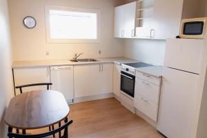 Il comprend une petite cuisine avec une table et un réfrigérateur blanc. dans l'établissement 1 BR apartment for 4 guests in Tórshavn, à Tórshavn