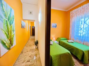 due letti in una stanza con pareti gialle di Orange House a Isola delle Femmine