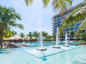 a swimming pool with a fountain in front of a building at Diamond Beach Villa Da Nang in Da Nang