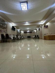 a large room with tables and chairs and a large white floor at Sharq Plaza in Bukhara