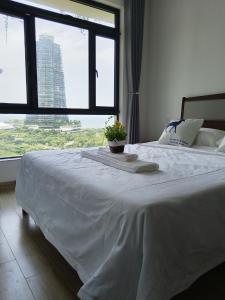 星海湾宿 في Kampong Tanjong Kupang: غرفة نوم بسرير ابيض مع نافذة