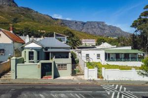 uma casa numa rua com montanhas ao fundo em Quirky 2 Bed Home Parking Wi-Fi Backup Power em Cidade do Cabo