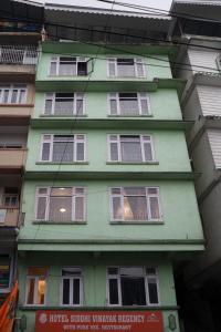 a green building with many windows on the side of it at Hotel Siddhi Vinayak Regency,near Mg Marg, Gangtok in Gangtok