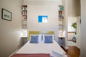 a bedroom with a bed with blue and white pillows at Quirky 2 Bed Home Parking Wi-Fi Backup Power in Cape Town