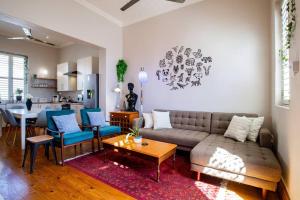 uma sala de estar com um sofá e cadeiras e uma cozinha em Quirky 2 Bed Home Parking Wi-Fi Backup Power em Cidade do Cabo