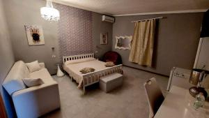 a bedroom with a bed and a couch and a chair at Il Mirto E La Rosa in Arenella