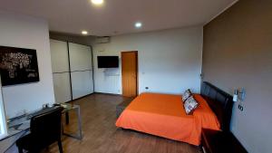 a bedroom with a bed and a desk and a television at Il Mirto E La Rosa in Arenella