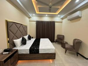 Gold Pine Hotel and Apartments في لاهور: غرفة نوم بسرير ومكتب وكرسي