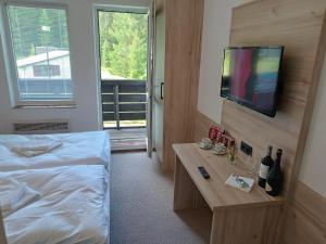 a bedroom with a bed and a table with wine bottles at Hotel Bečva na Horní Bečvě in Horní Bečva