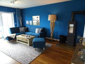 a living room with blue walls and a blue couch at Gode Wind Quartiere 7 in Dahme