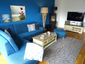 a blue living room with a blue couch and a table at Gode Wind Quartiere 7 in Dahme