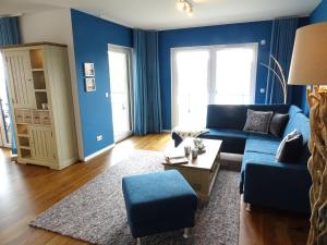 a living room with blue walls and a blue couch at Gode Wind Quartiere 7 in Dahme