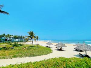 峴港的住宿－Astana Villa Non Nuoc Beach，海滩上设有遮阳伞和椅子,还有大海