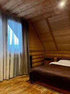 a bedroom with a bed and a large window at Тихий куточок in Izki