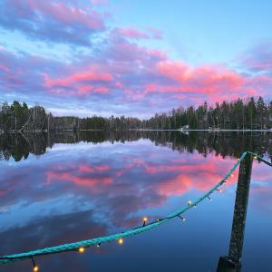 a lake with a string of lights in the water at Lake view apartment, Espoo in Espoo
