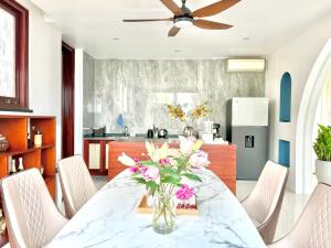 une salle à manger avec une table avec un vase de fleurs dans l'établissement Mattina Villa, à Hạ Long