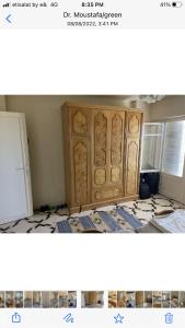 Zimmer mit einem Holzschrank in einem Zimmer in der Unterkunft الميرغني مصر الجديده in El-Alamein