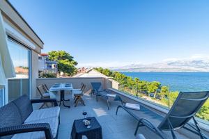 a balcony with chairs and tables and a view of the ocean at Vila Inga - Postira in Postira