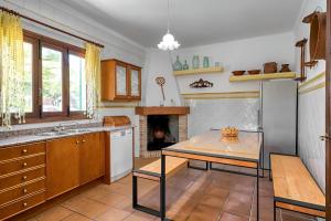 a kitchen with a table and a fireplace at Finca Sa Punta in Santa Margalida