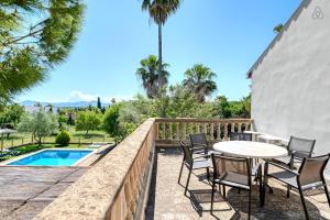 a patio with a table and chairs next to a pool at Finca Sa Punta in Santa Margalida