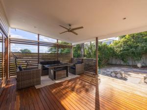 a patio with a ceiling fan and furniture on a deck at 6KM to CBD Convenient 5BR Queenslander Coorparoo in Brisbane