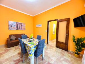 una sala da pranzo con un tavolo e un divano di Orange House a Isola delle Femmine