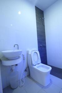 uma casa de banho com um WC branco e um lavatório. em Astrotel Avenida em Manila
