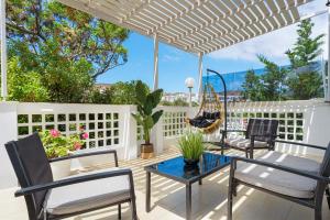 阿達瑪斯的住宿－Semiramis Guesthouse，白色围栏上带椅子和吊床的庭院