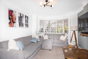 a living room with a gray couch and a table at Pass the Keys Stunning home near Didsbury Village - Sleeps 6 in Manchester
